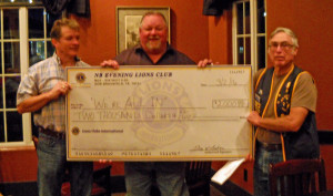 some and someone Dean, representing the We're All In organization receive our club's donation from President Grey Baker.